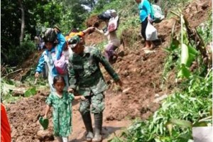 Salah seorang anggota TNI saat membantu warga yangt terkena musibah longsor.